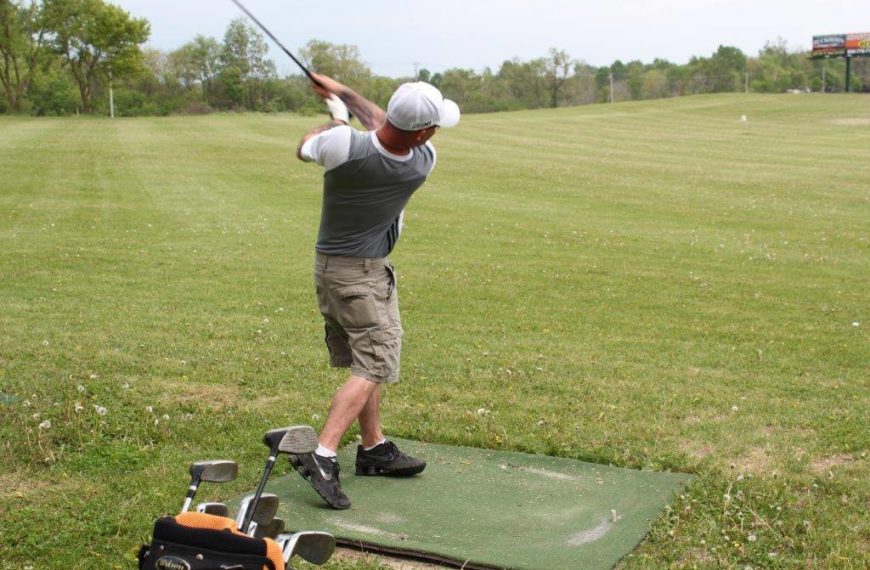 Photo of man's back swing after hitting a ball on the driving range at 59er driving range