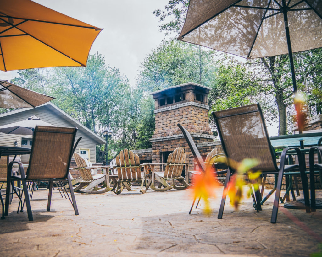 Patio space with chairs, tables, and a fireplace at Fermenting Cellars Winery