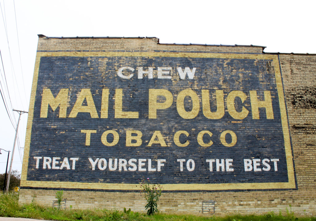 A fading advertisement for Mail Pouch Chewing Tobacco on the side of a former tobacco warehouse